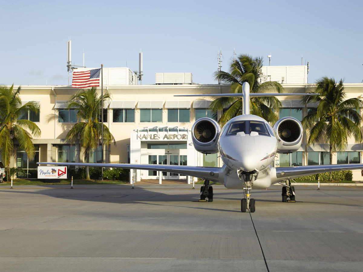 A white airplane parked on the tarmac, ready for takeoff.